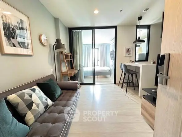 Modern living room with stylish decor and open layout leading to a cozy bedroom.