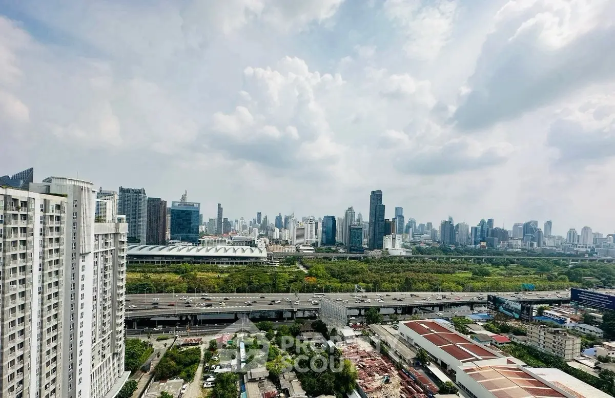 Stunning cityscape view from high-rise building showcasing urban skyline and lush greenery.