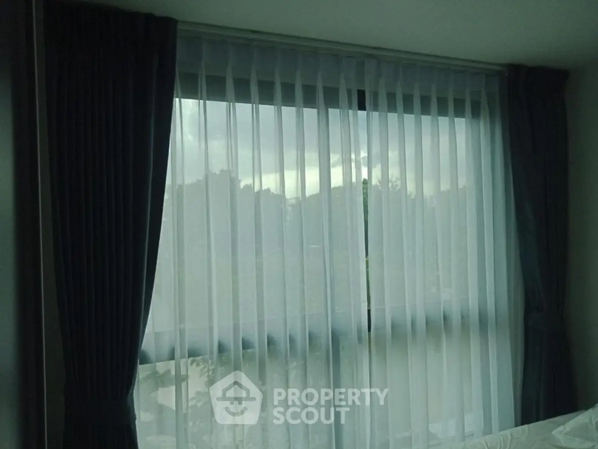 Elegant bedroom window with lush green view and stylish curtains