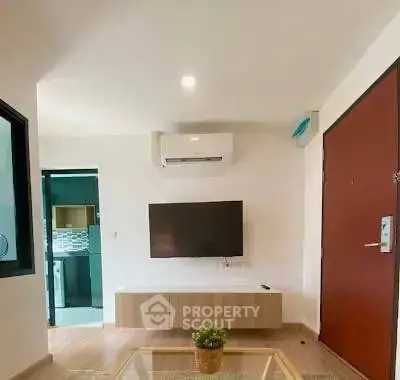 Modern living room with wall-mounted TV and air conditioning unit, featuring sleek design and natural lighting.
