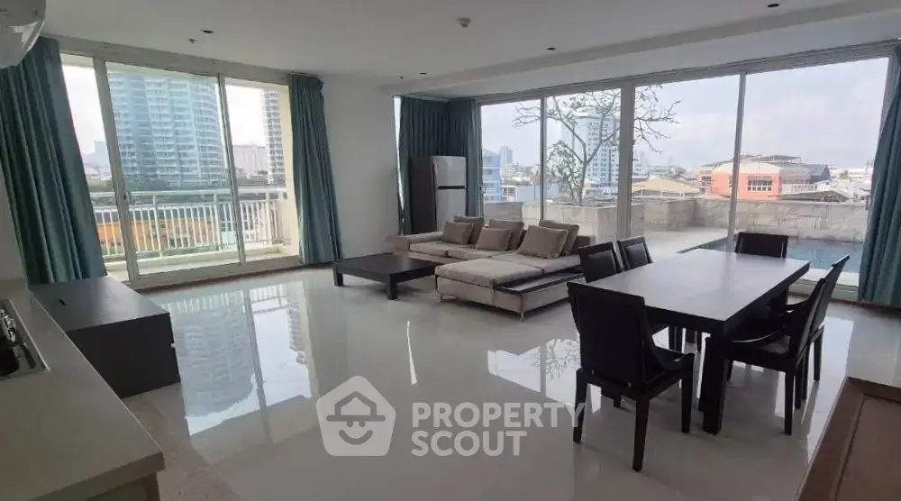 Spacious modern living room with large windows and city view, featuring elegant furniture and open layout.