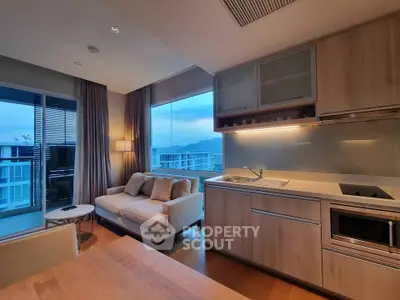Modern open-layout living room with kitchen and balcony view