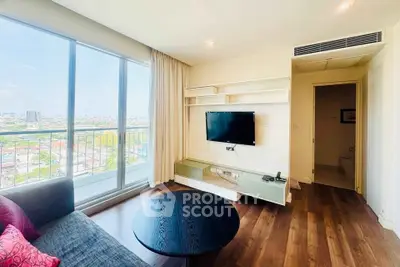 Modern living room with city view, featuring sleek TV setup and cozy seating area.