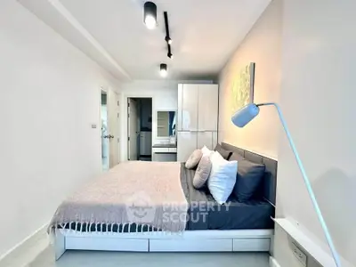 Modern bedroom with sleek design and ample natural light, featuring a cozy bed and stylish decor.