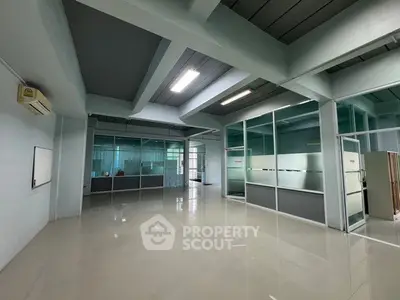 Spacious modern office space with glass partitions and tiled flooring