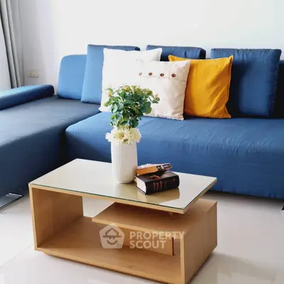 Modern living room with stylish blue sofa and elegant coffee table.