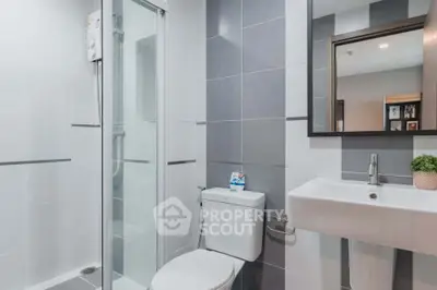 Modern bathroom with sleek design, featuring a glass shower enclosure and stylish fixtures.