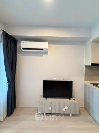 Modern living room with air conditioning and sleek TV setup in a stylish apartment.