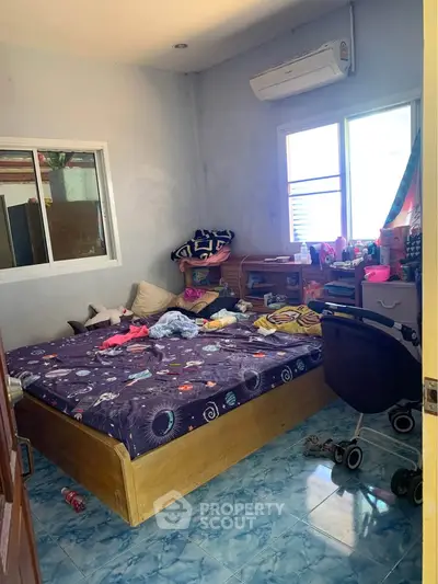 Cozy bedroom with air conditioning and colorful decor, perfect for a comfortable living space.