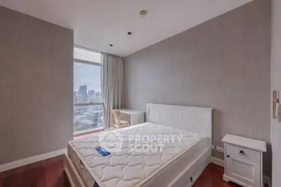 Spacious bedroom with city view, featuring a large window and modern furnishings.