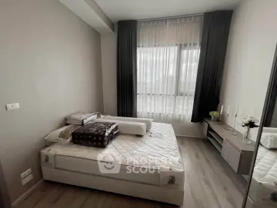 Modern bedroom with large window and stylish decor in a contemporary apartment.