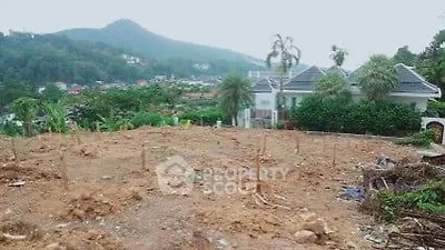 Scenic plot of land with mountain views and nearby house for sale
