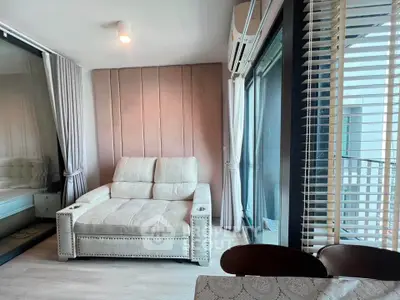 Modern living room with plush sofa and large windows offering natural light