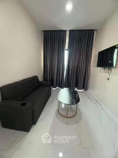 Modern living room with sleek black sofa, marble coffee table, and wall-mounted TV, featuring elegant floor-to-ceiling curtains.