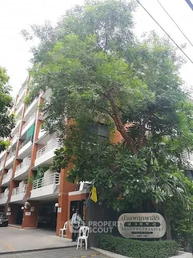 Charming multi-story residential building with lush greenery and inviting entrance.