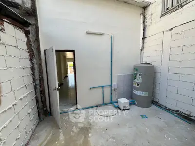 Spacious utility area with water tank and open doorway in modern home