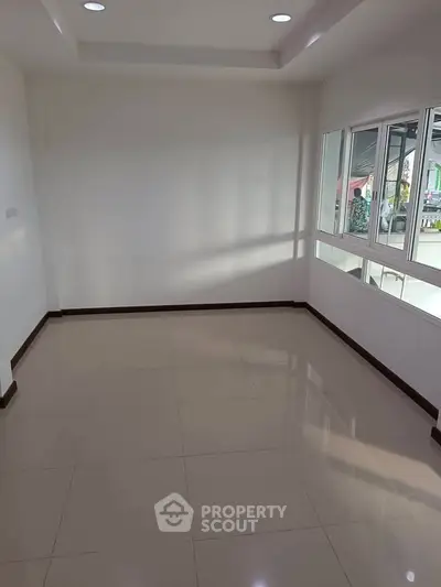 Spacious empty room with large windows and glossy tiled floor, perfect for customization.