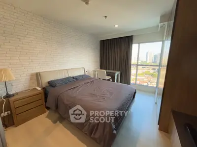 Modern bedroom with city view, featuring a cozy bed and stylish decor.
