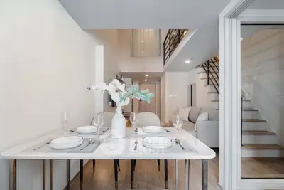 Modern duplex dining area with elegant table setting and stylish staircase
