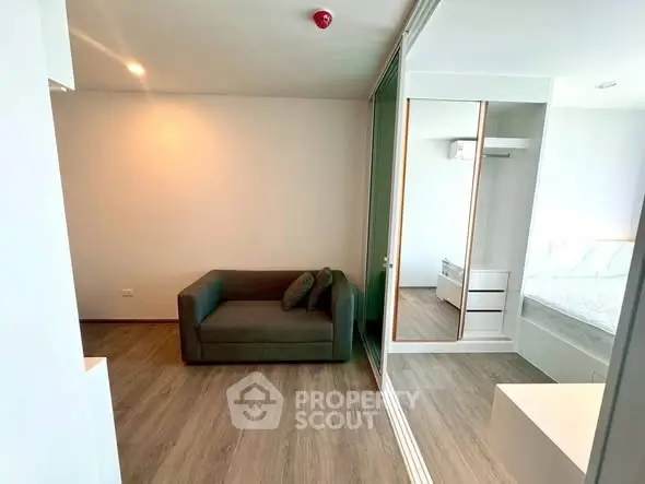 Modern living room with sleek design and mirrored wardrobe in a stylish apartment.