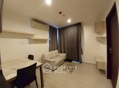Modern living room with sofa, dining table, and air conditioning.
