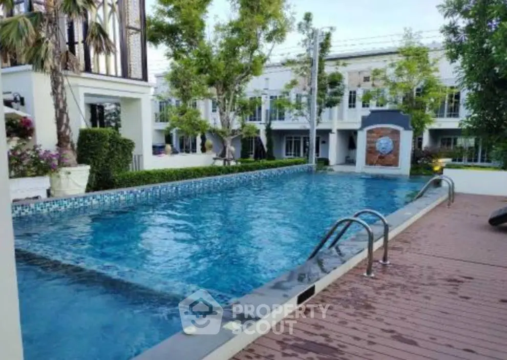 Luxurious residential pool area with modern design and lush greenery.