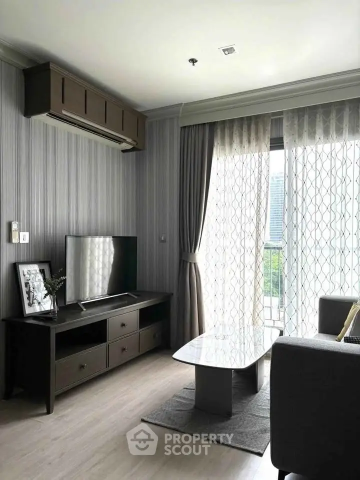 Modern living room with stylish decor and large window offering natural light and scenic view.