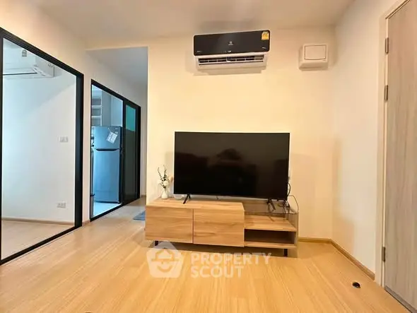 Modern living room with sleek TV setup and air conditioning in stylish apartment.