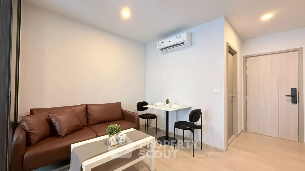 Modern living room with cozy seating and dining area, featuring sleek air conditioning unit.