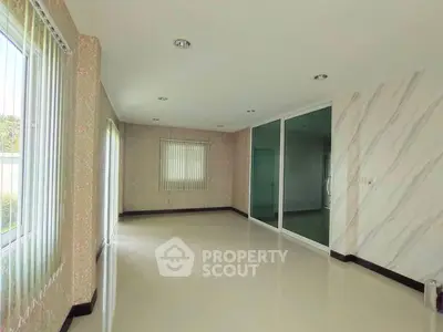 Spacious empty room with large windows and sliding glass doors