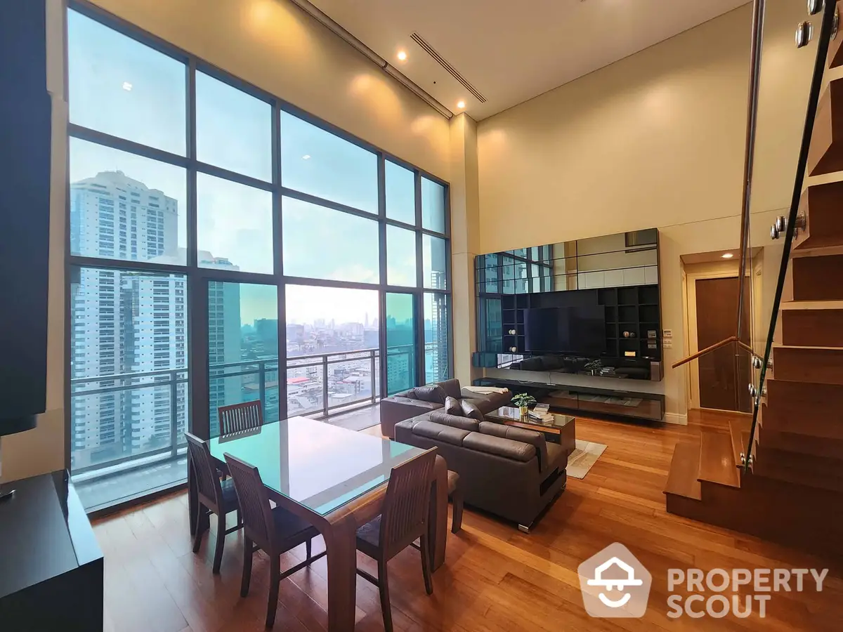 Luxurious two-story living space with floor-to-ceiling windows offering a panoramic city view, modern kitchen, and elegant wooden flooring.