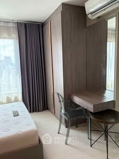Modern bedroom with city view, featuring sleek furniture and large windows.