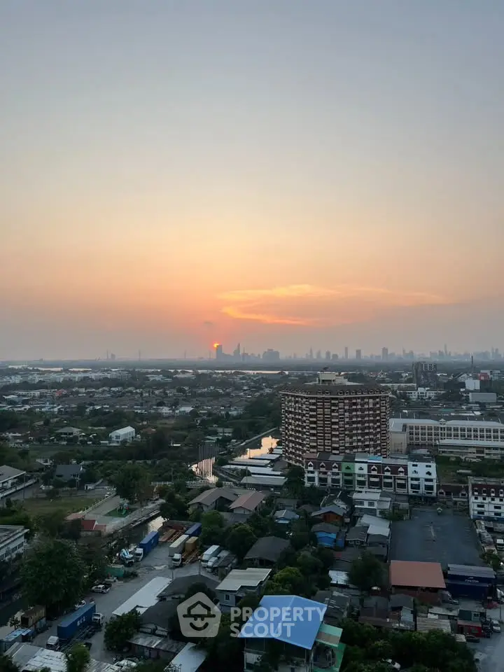 Stunning cityscape view at sunset from a high-rise building, showcasing urban skyline and vibrant horizon.