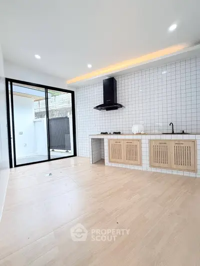 Modern kitchen with open layout and sleek design, featuring gas stove and ample natural light.
