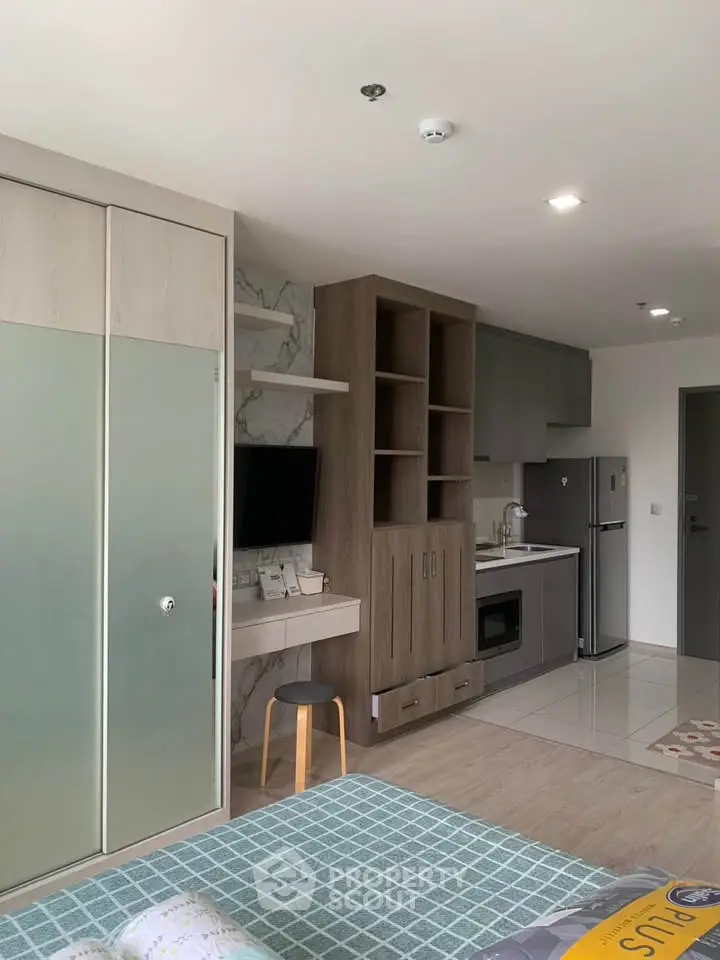 Modern studio apartment with sleek kitchen and cozy living area, perfect for urban living.