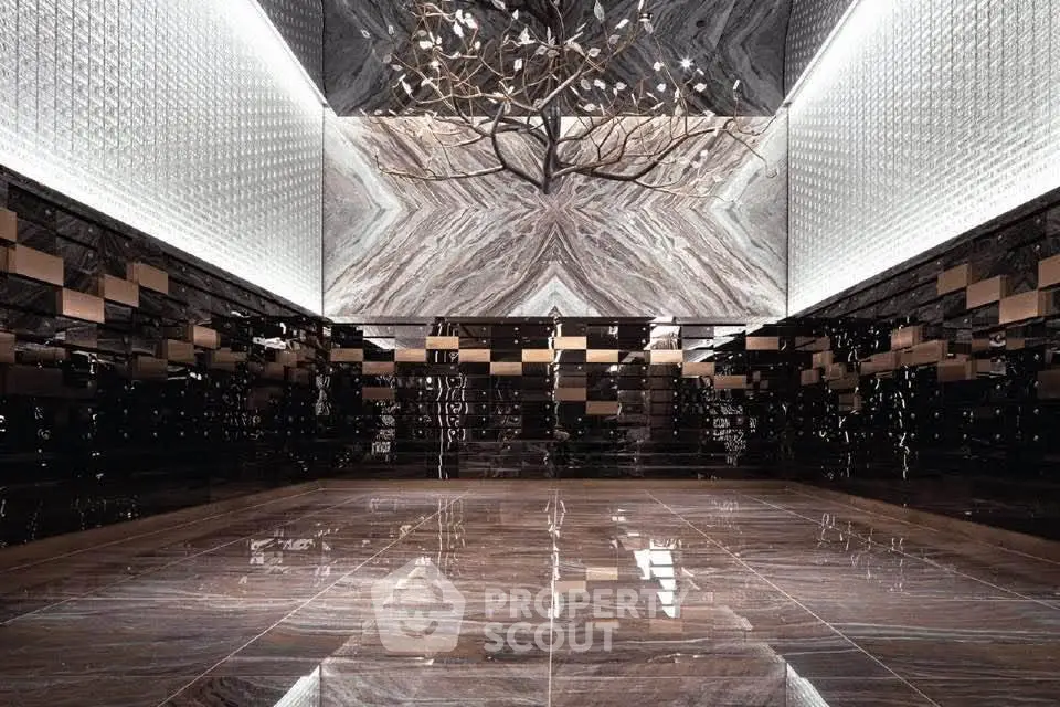 Luxurious modern lobby with stunning marble walls and unique lighting fixture.