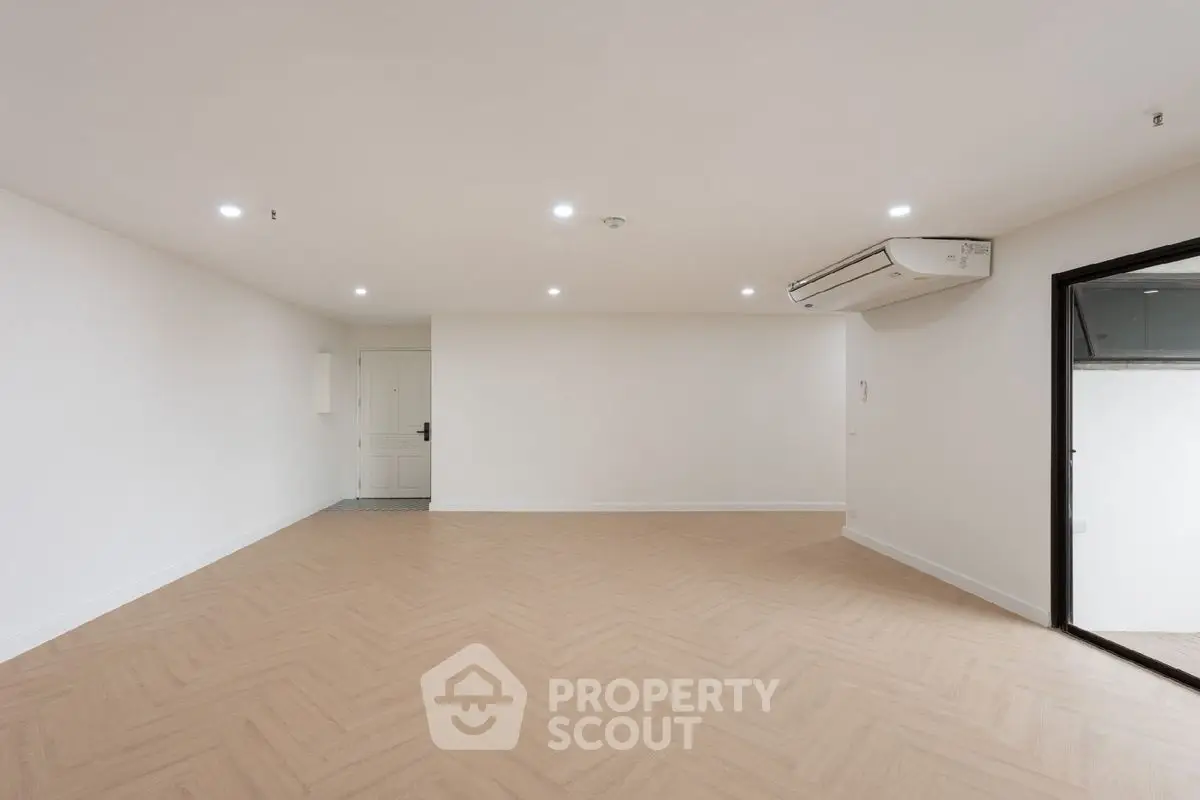Spacious empty room with modern air conditioning and wooden flooring