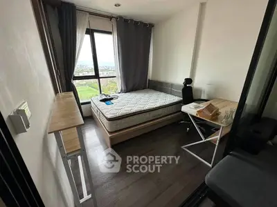 Cozy bedroom with large window offering a scenic view, featuring a comfortable bed and modern desk setup.