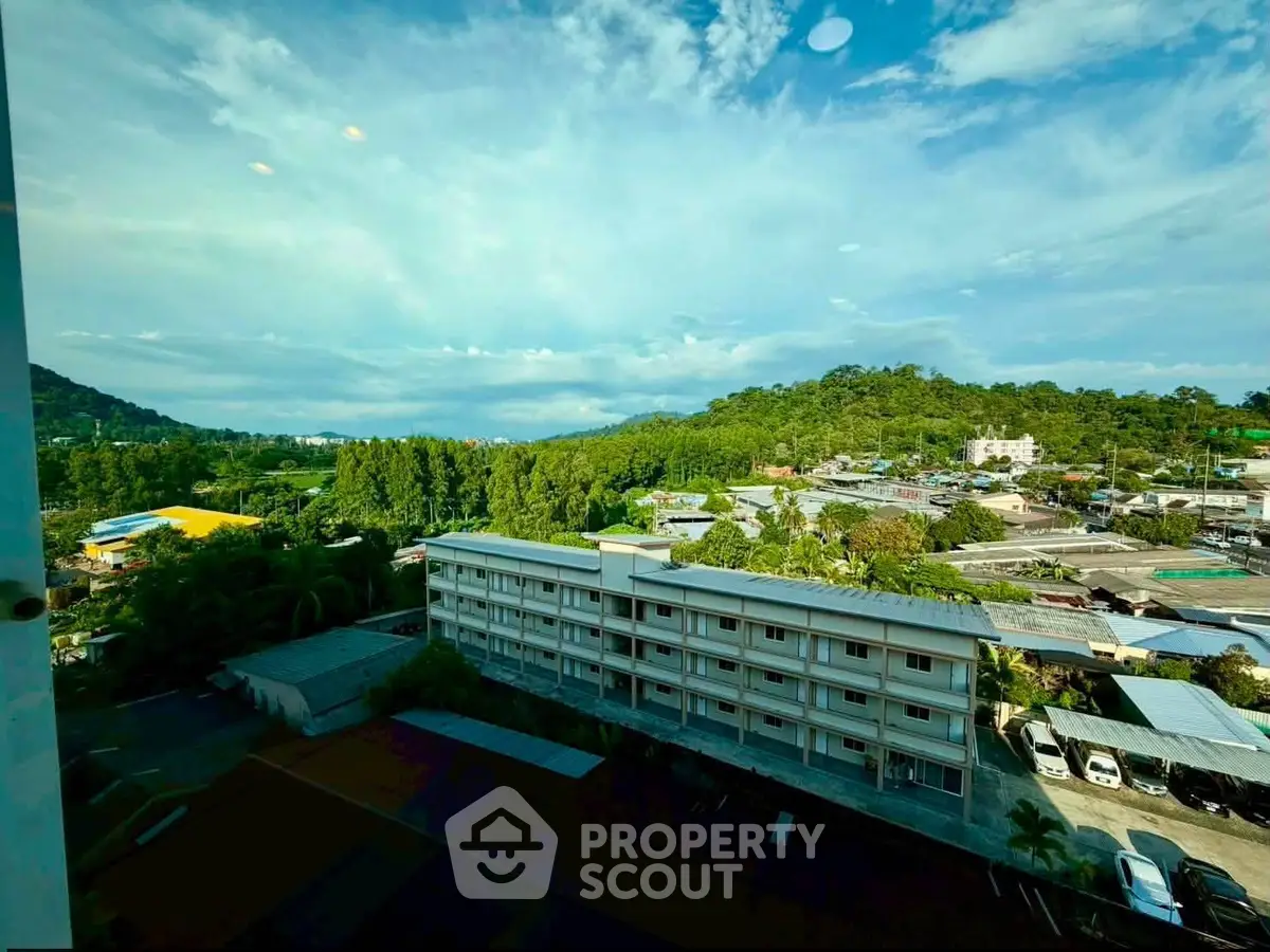 Scenic view from a high-rise building overlooking lush greenery and residential area.