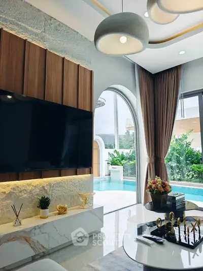 Luxurious living room with pool view, modern decor, and elegant lighting in a high-end property.
