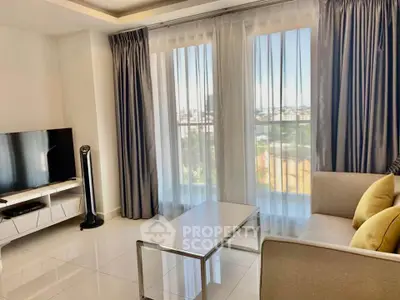 Modern living room with large windows and stylish decor in a high-rise apartment.