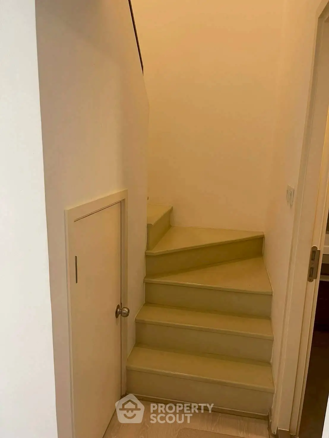 Charming interior staircase with unique storage door, perfect for maximizing space in modern homes.