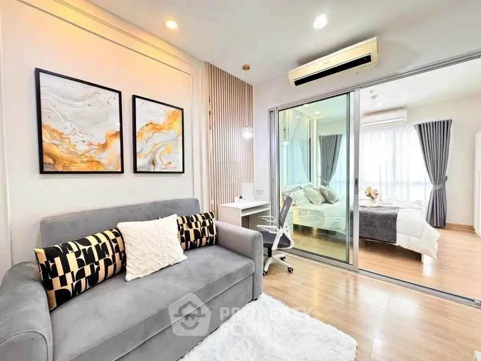 Modern living room with stylish decor and sliding glass doors leading to a cozy bedroom.