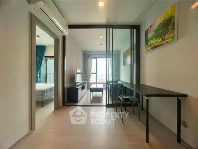Modern apartment interior with open layout, featuring a spacious living area and large windows for natural light.