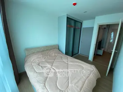 Cozy bedroom with modern design and ample natural light, featuring a comfortable bed and sleek wardrobe.