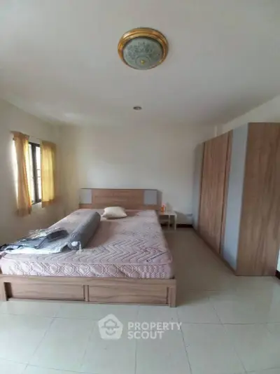 Spacious bedroom with large bed and ample natural light, perfect for relaxation.