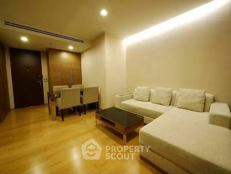 Modern living room with cozy sectional sofa and elegant dining area in open layout.
