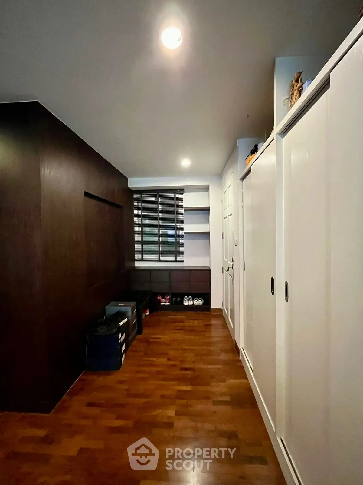 Spacious storage room with wooden flooring and ample shelving space.