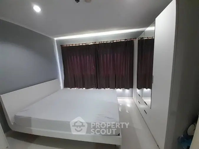 Sleek modern bedroom with ambient lighting, large bed, and expansive built-in wardrobes, featuring a cozy atmosphere and minimalist design.