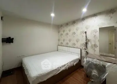 Cozy bedroom with modern decor and stylish wallpaper, perfect for relaxation and comfort.
